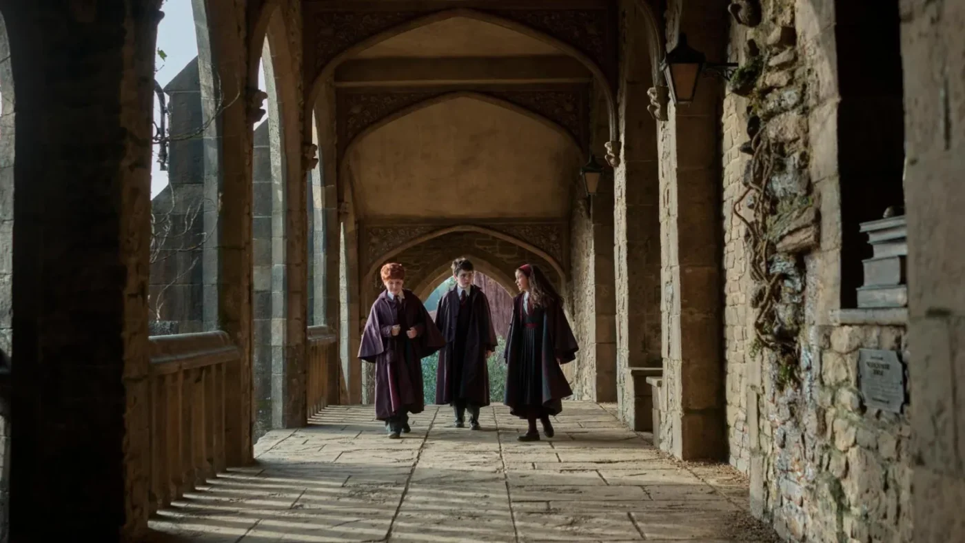 Aidan Monaghan/HBO Max/PA Wire Alastair Stout as Ron Weasley, Dominic McLaughlin as Harry Potter and Arabella Stanton as Hermione Granger walk the halls of Hogwarts in their wizarding robes in HBO Max