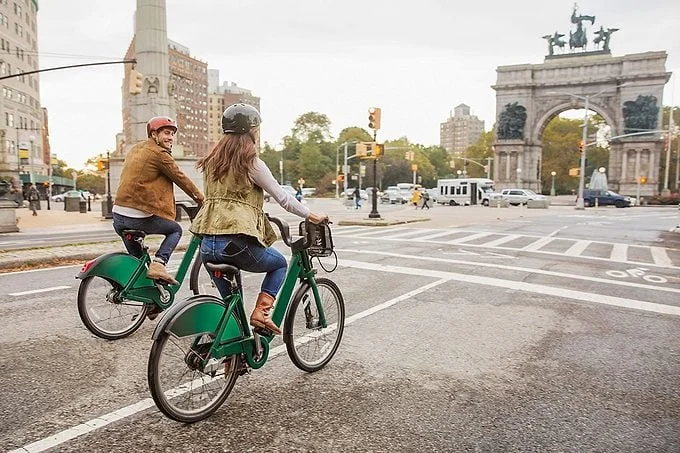 Couple riding bicycle on city street